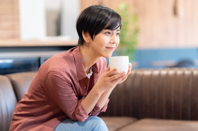 コーヒーを飲むショートカットの女性